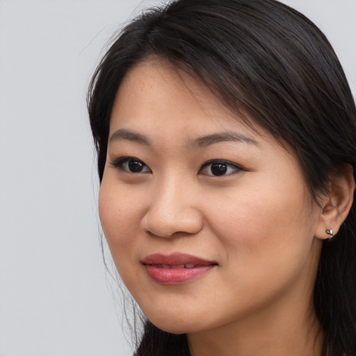 Joyful asian young-adult female with long  brown hair and brown eyes