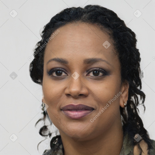 Joyful black young-adult female with long  black hair and brown eyes