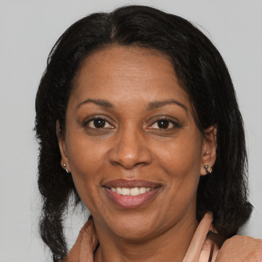 Joyful black adult female with medium  brown hair and brown eyes