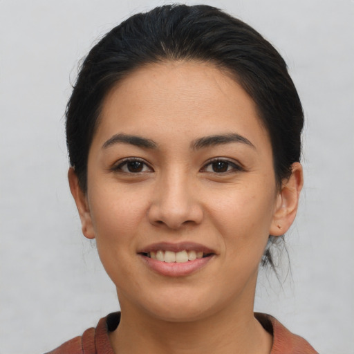 Joyful latino young-adult female with medium  brown hair and brown eyes