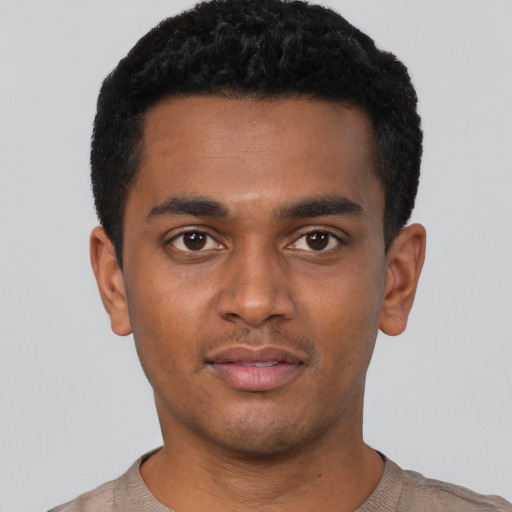 Joyful black young-adult male with short  black hair and brown eyes