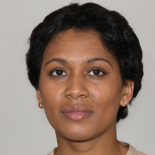 Joyful black young-adult female with short  black hair and brown eyes
