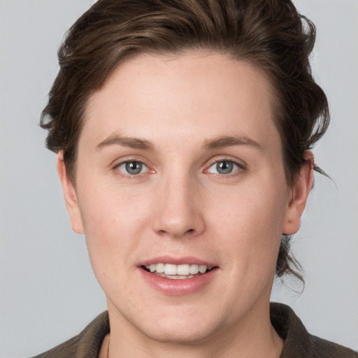 Joyful white young-adult female with medium  brown hair and grey eyes