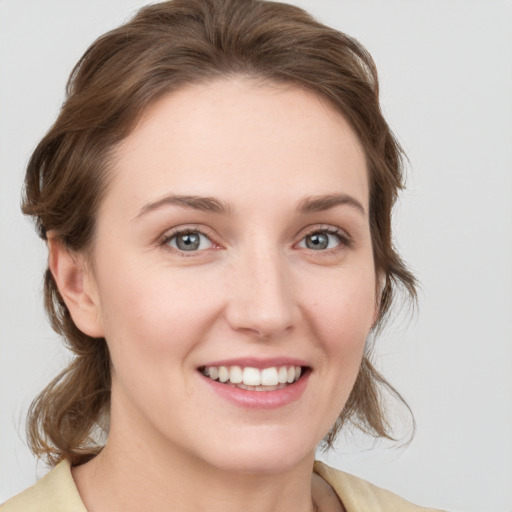 Joyful white young-adult female with medium  brown hair and grey eyes