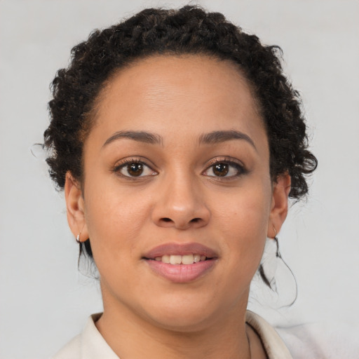 Joyful black young-adult female with short  brown hair and brown eyes