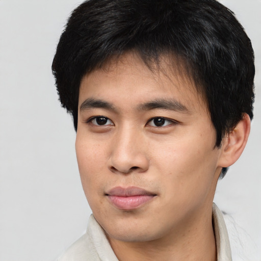 Joyful asian young-adult male with short  black hair and brown eyes
