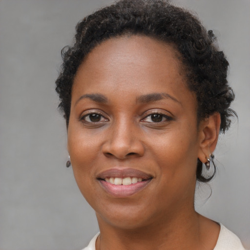 Joyful black young-adult female with short  brown hair and brown eyes
