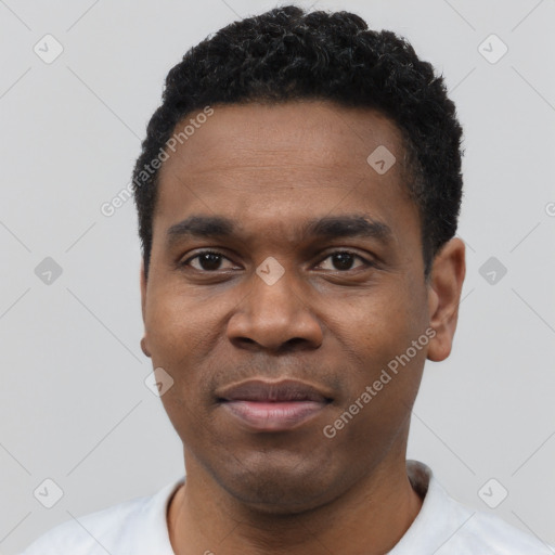 Joyful black young-adult male with short  black hair and brown eyes