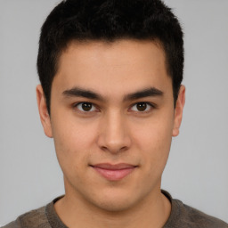 Joyful latino young-adult male with short  brown hair and brown eyes