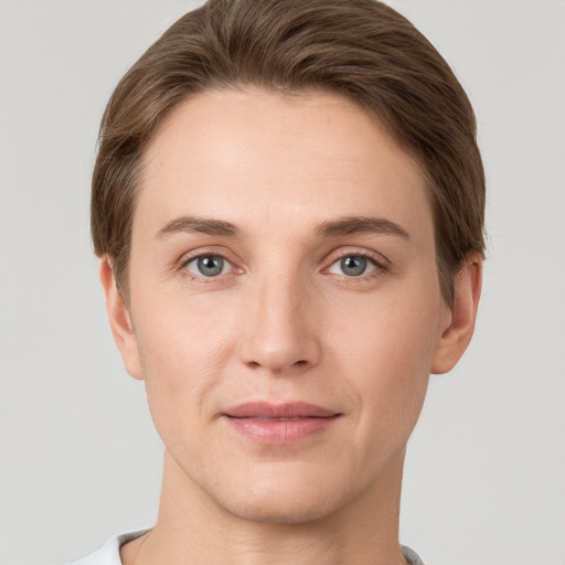 Joyful white young-adult female with short  brown hair and grey eyes