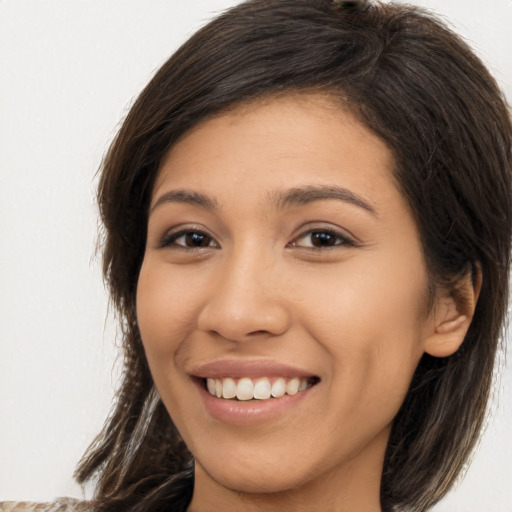 Joyful latino young-adult female with long  brown hair and brown eyes