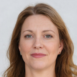 Joyful white adult female with long  brown hair and grey eyes