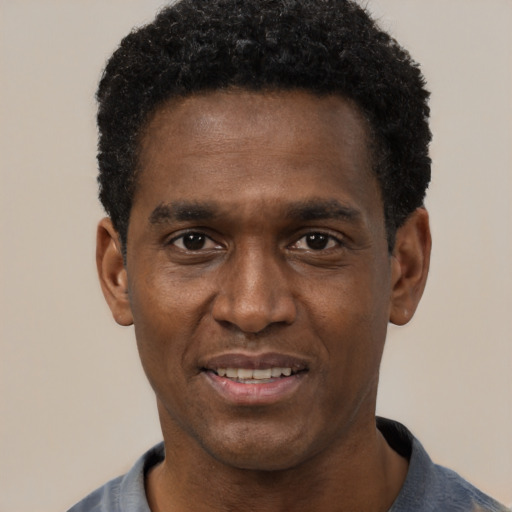 Joyful black young-adult male with short  black hair and brown eyes