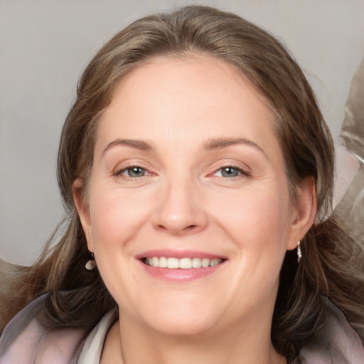 Joyful white adult female with medium  brown hair and blue eyes