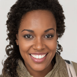 Joyful black young-adult female with long  brown hair and brown eyes