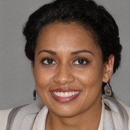 Joyful black adult female with short  brown hair and brown eyes