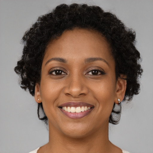 Joyful black young-adult female with medium  brown hair and brown eyes