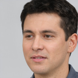 Joyful white young-adult male with short  black hair and brown eyes