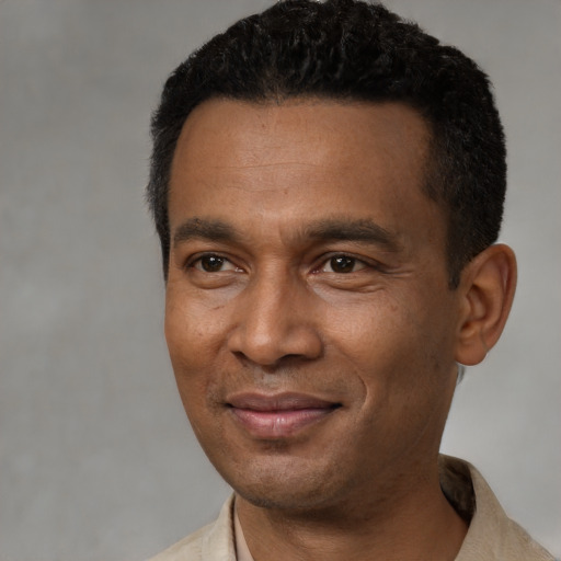 Joyful black young-adult male with short  black hair and brown eyes