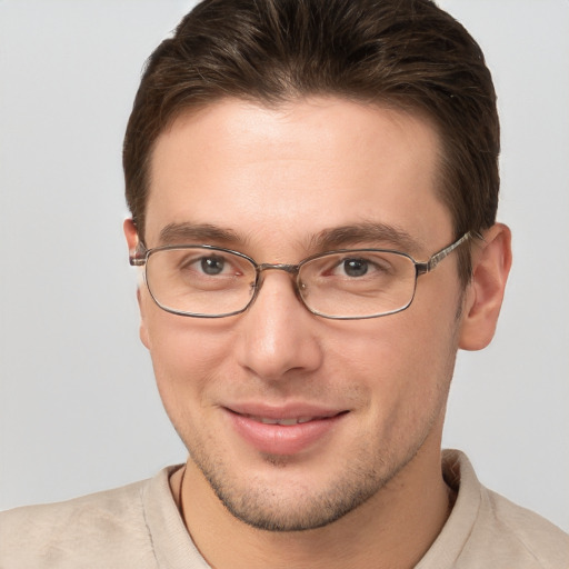 Joyful white young-adult male with short  brown hair and grey eyes