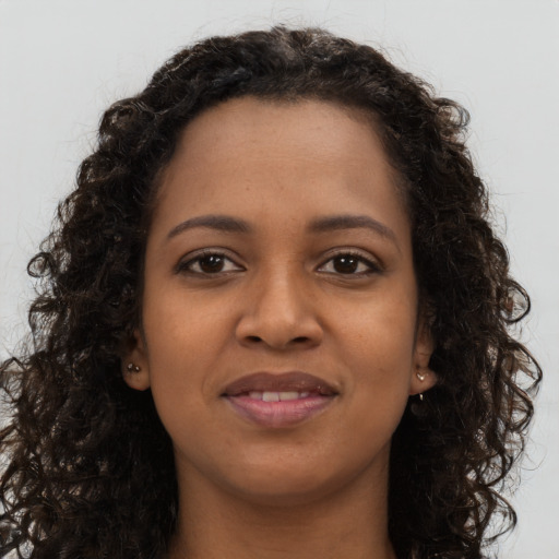 Joyful black young-adult female with long  brown hair and brown eyes
