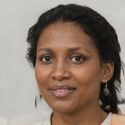 Joyful black adult female with medium  brown hair and brown eyes