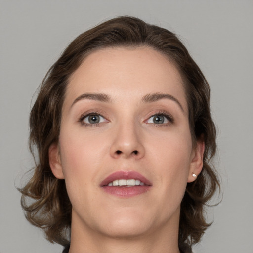 Joyful white young-adult female with medium  brown hair and grey eyes