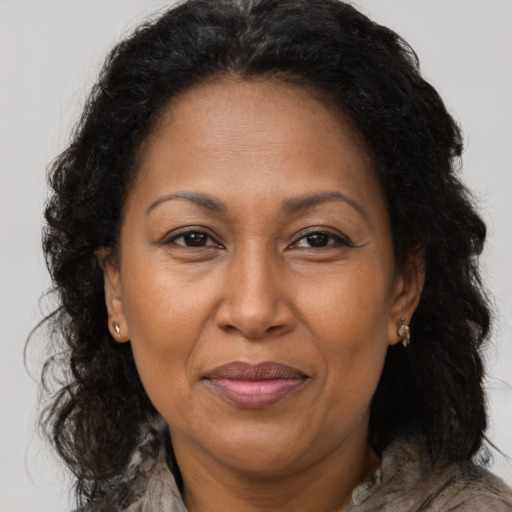 Joyful black adult female with long  brown hair and brown eyes