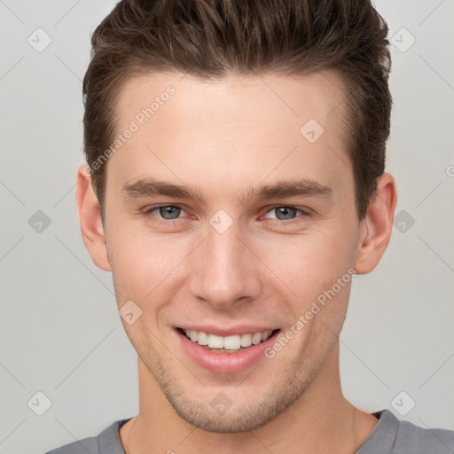 Joyful white young-adult male with short  brown hair and grey eyes