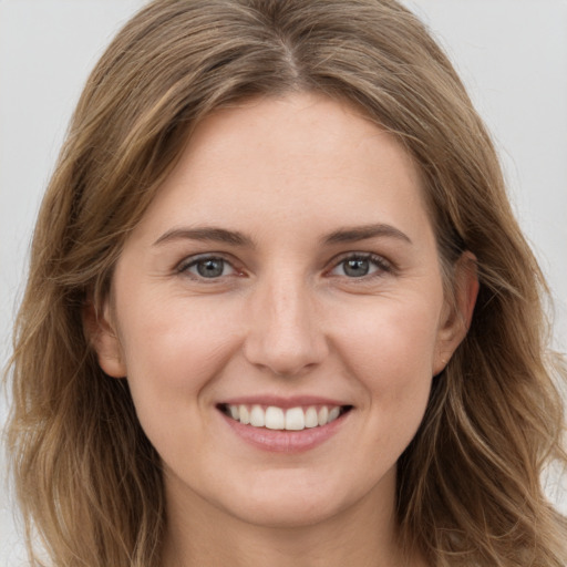 Joyful white young-adult female with long  brown hair and grey eyes