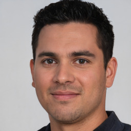 Joyful white young-adult male with short  black hair and brown eyes