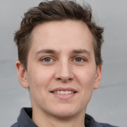 Joyful white adult male with short  brown hair and grey eyes