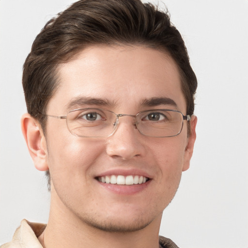 Joyful white young-adult male with short  brown hair and grey eyes