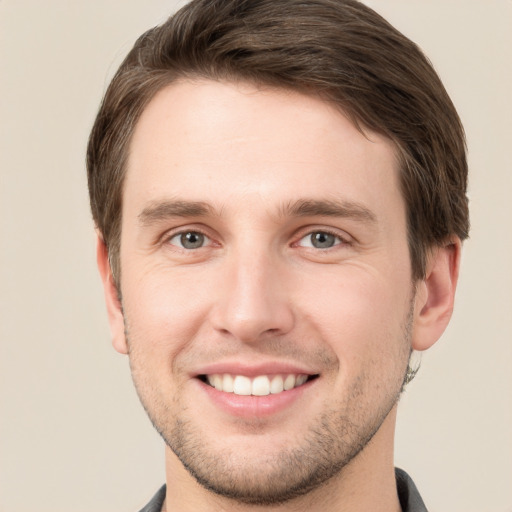 Joyful white young-adult male with short  brown hair and grey eyes