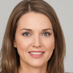 Joyful white young-adult female with long  brown hair and green eyes