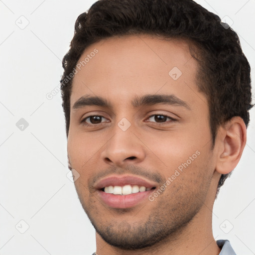 Joyful white young-adult male with short  black hair and brown eyes