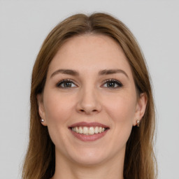 Joyful white young-adult female with long  brown hair and grey eyes