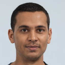 Joyful latino young-adult male with short  brown hair and brown eyes