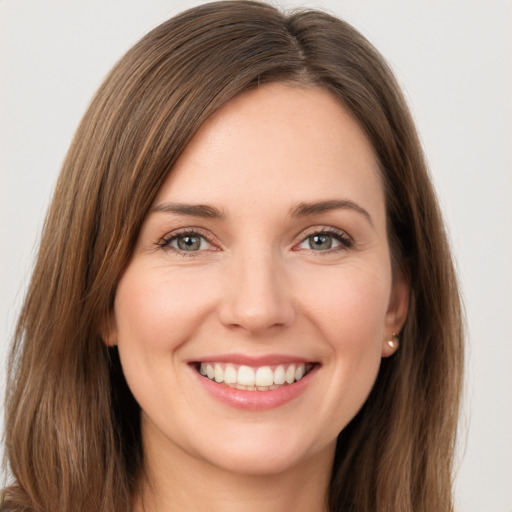 Joyful white young-adult female with long  brown hair and brown eyes