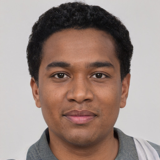 Joyful black young-adult male with short  black hair and brown eyes