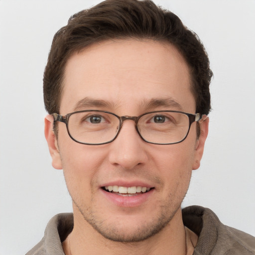 Joyful white young-adult male with short  brown hair and grey eyes