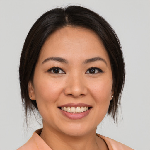 Joyful asian young-adult female with medium  brown hair and brown eyes