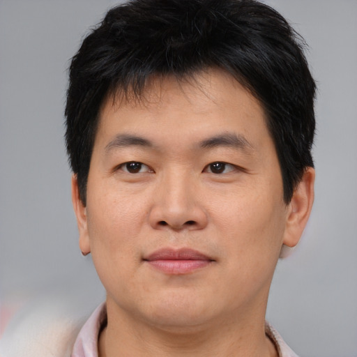 Joyful asian young-adult male with short  brown hair and brown eyes