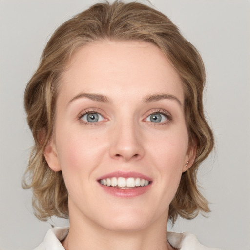 Joyful white young-adult female with medium  brown hair and blue eyes