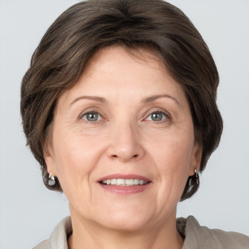 Joyful white adult female with medium  brown hair and grey eyes