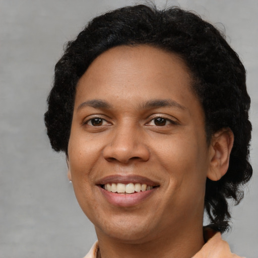 Joyful black young-adult female with short  brown hair and brown eyes
