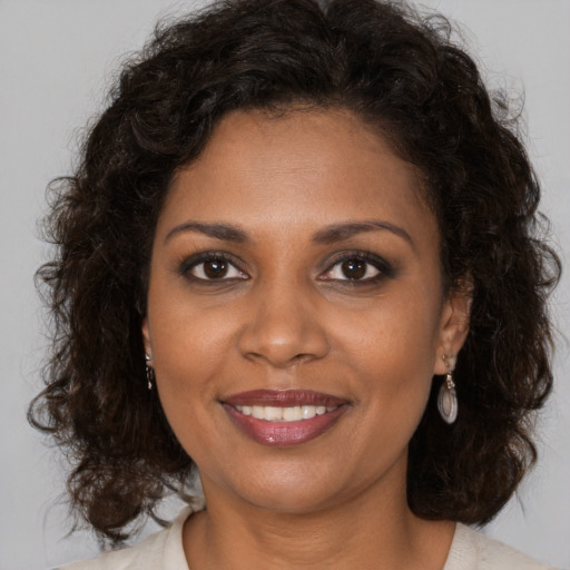 Joyful black young-adult female with medium  brown hair and brown eyes