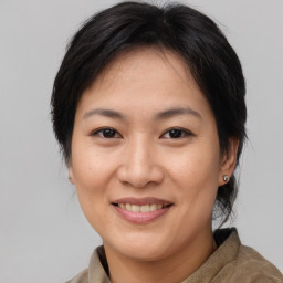 Joyful asian adult female with medium  brown hair and brown eyes