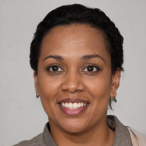 Joyful black adult female with short  black hair and brown eyes
