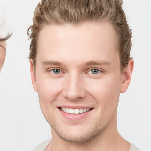 Joyful white young-adult male with short  brown hair and grey eyes